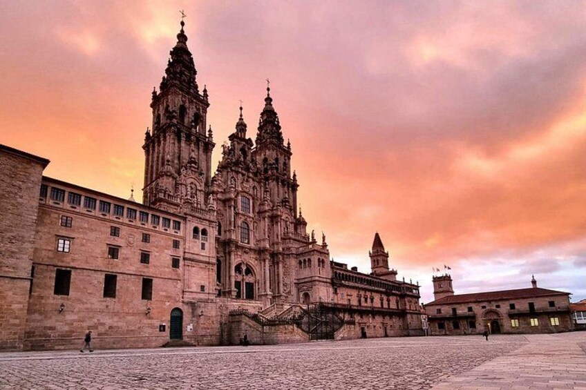 A historic cathedral with two prominent towers, a cobblestone plaza, and a cloudy sky. 5