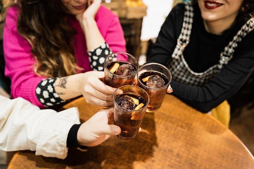 Three people toasting with drinks at a round table. 4