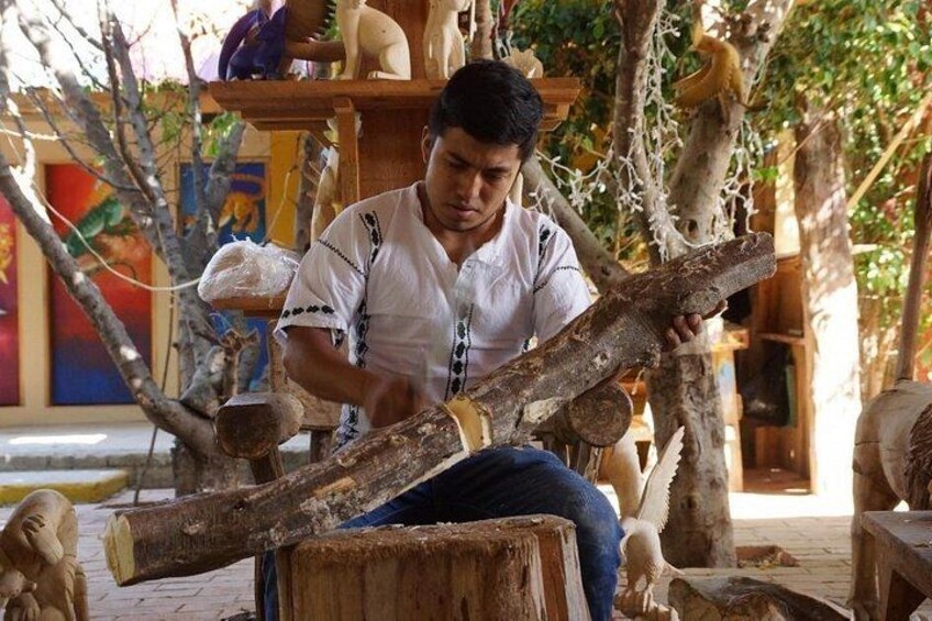 A person carving a log. 4