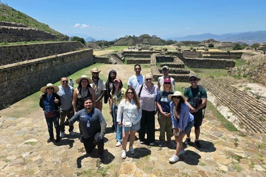 A group of people standing on ancient ruins with stone walls and terraced fields in the background. 3