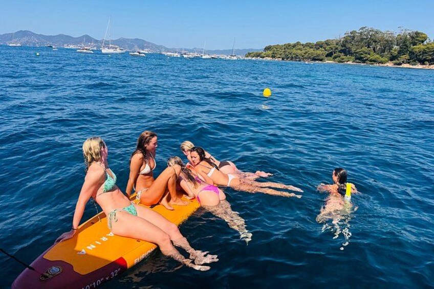A group of people on a boat in a body of water with a coastline in the background. 5