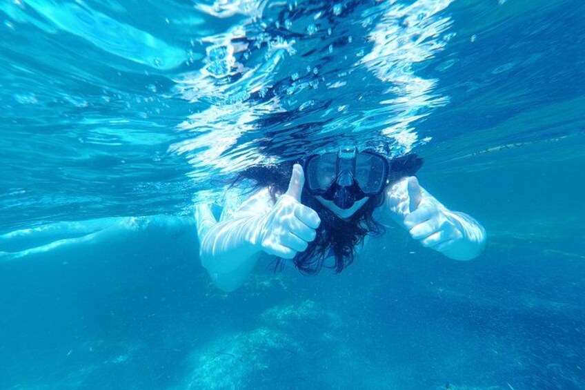 A person underwater giving a thumbs-up. 3