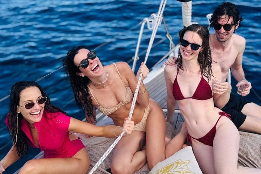 A group of people on a boat with a blue ocean in the background. 4