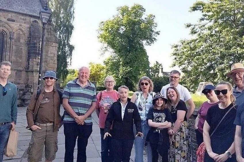 A group of people standing in front of a historic building with a church steeple. 4