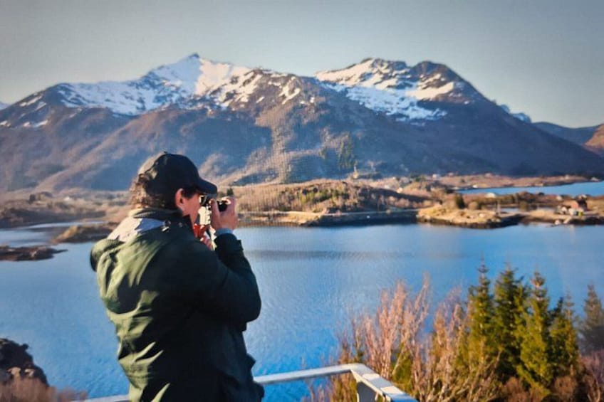 Iemand maakt een foto van een meer met bergen op de achtergrond. 2