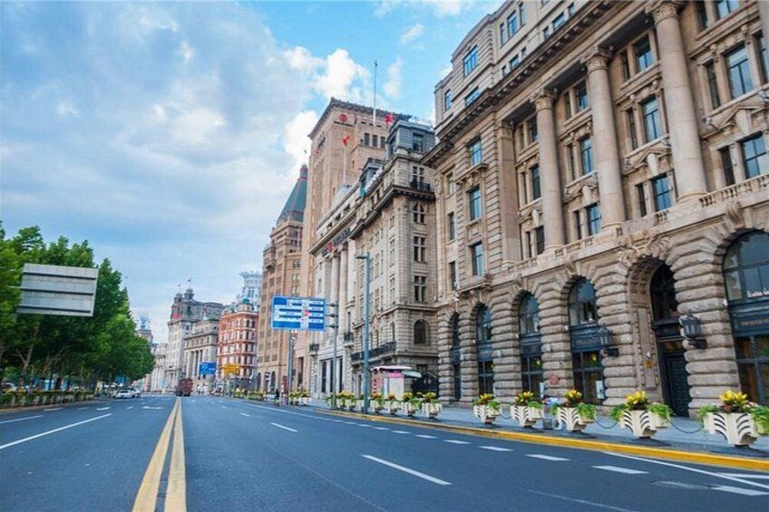 A wide, empty street lined with historic buildings and street signs. 5
