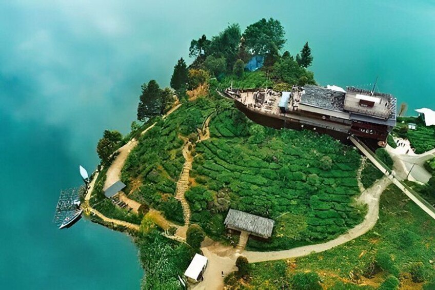 An aerial view of a coastal area with a shipwreck, a lighthouse, and a path leading through a green landscape. 2