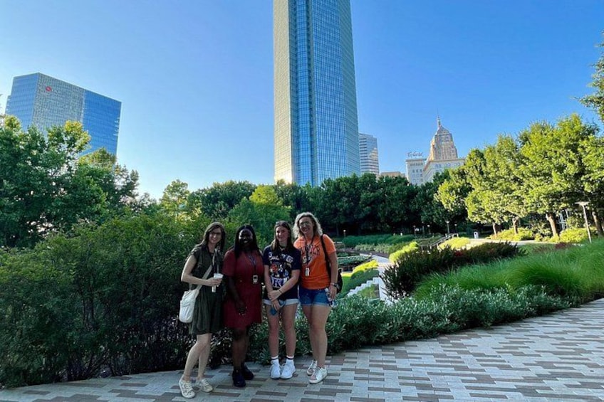 A group of people posing in a park with a cityscape in the background. 4