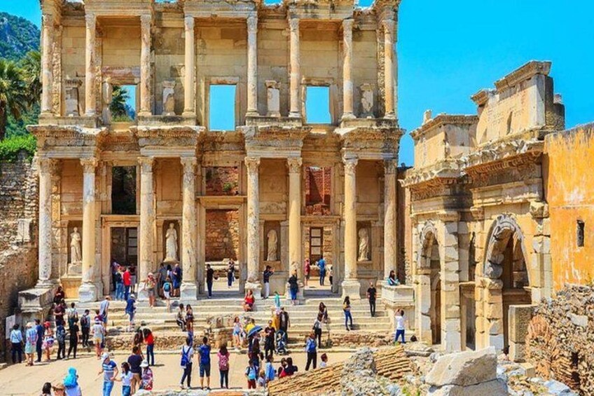 An ancient ruin with columns and steps, surrounded by tourists. 4