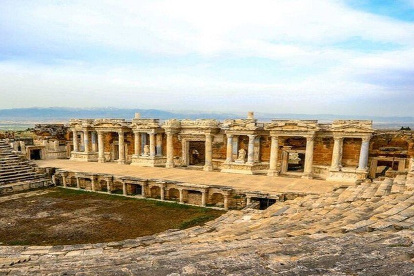 Ancient ruins with columns and a large open space. 2
