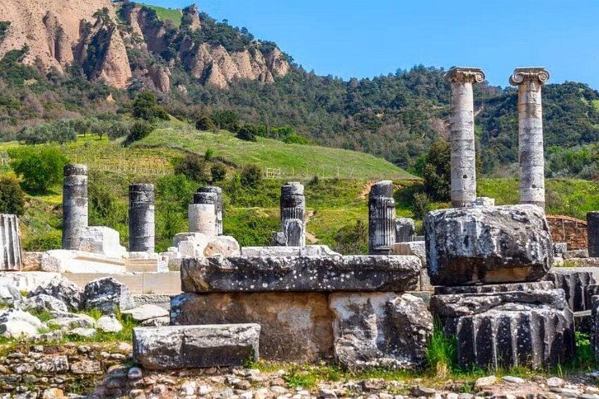 Ancient ruins with columns and stone structures in a hilly landscape. 5