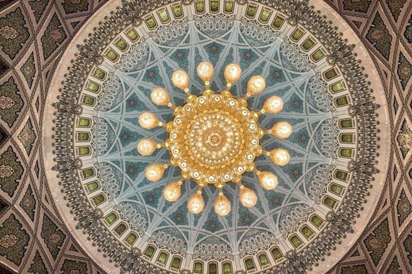 A detailed ceiling with a central circular design surrounded by geometric patterns. 2