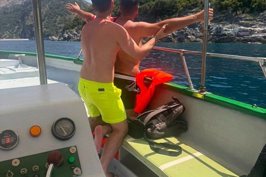 En båd med to personer, den ene i gule shorts og den anden i røde shorts, styrer båden. 3