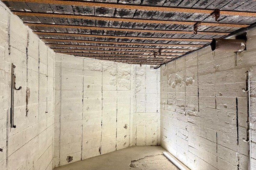 A room with exposed brick walls, a damaged ceiling, and a concrete floor. 2