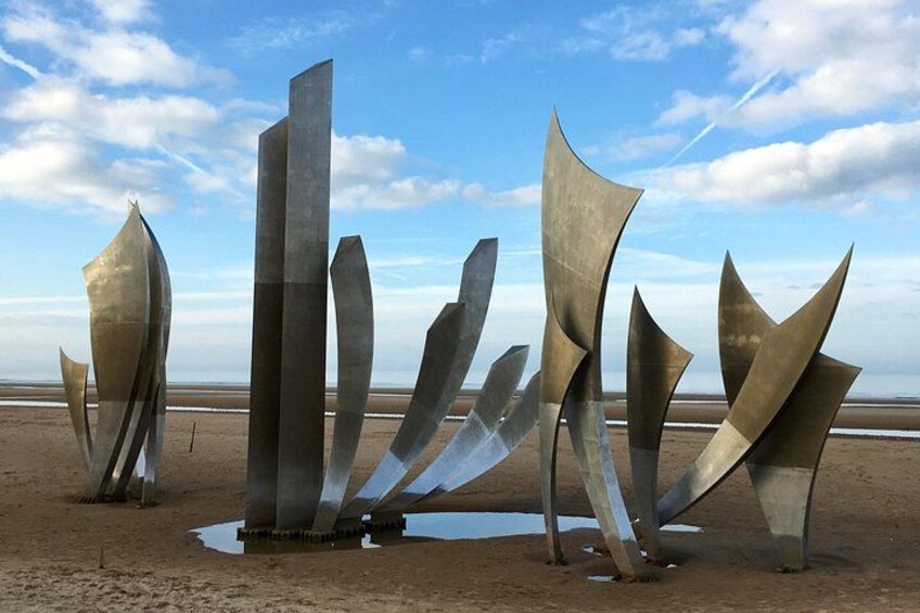 Abstract metal sculptures on a beach with a clear sky. 3