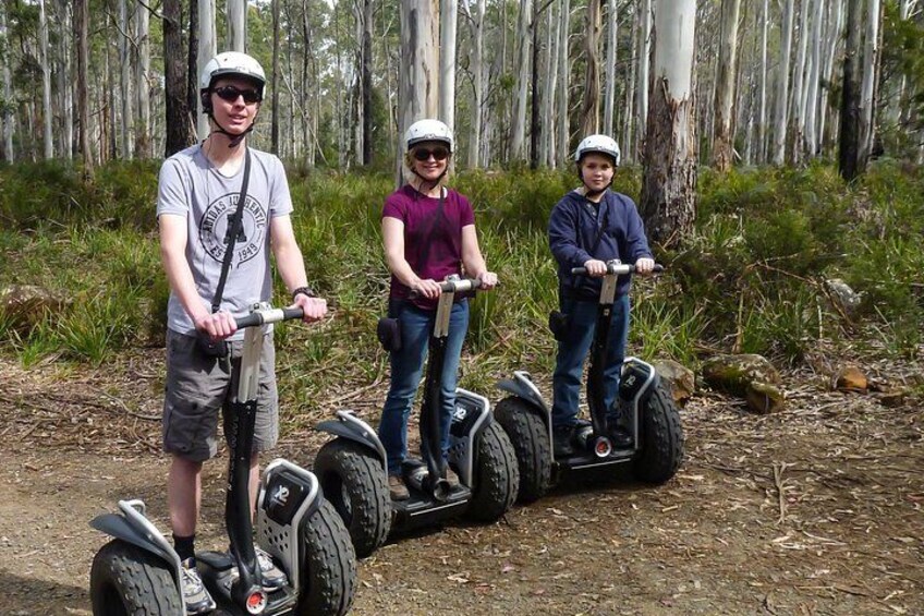 Tres personas en Segways en un área boscosa. 5