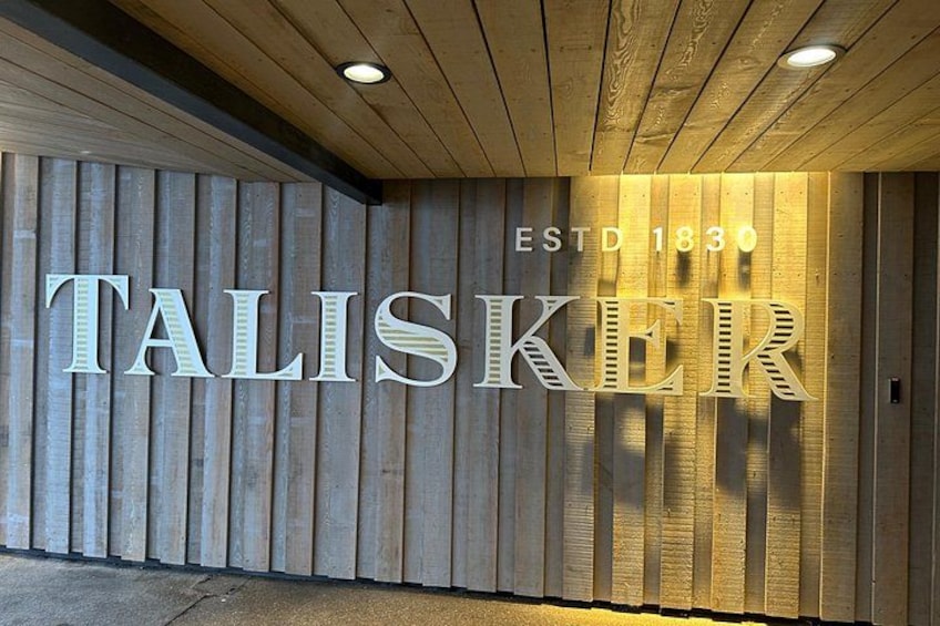 A wooden wall with the illuminated sign 'TALISKER ESTD 1830'. 5