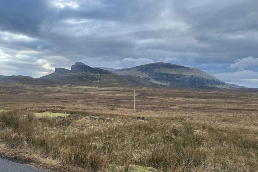 A barren landscape with rolling hills and a cloudy sky. 2
