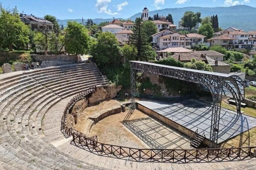 Un antiguo anfiteatro con asientos escalonados y una estructura de escenario. 5