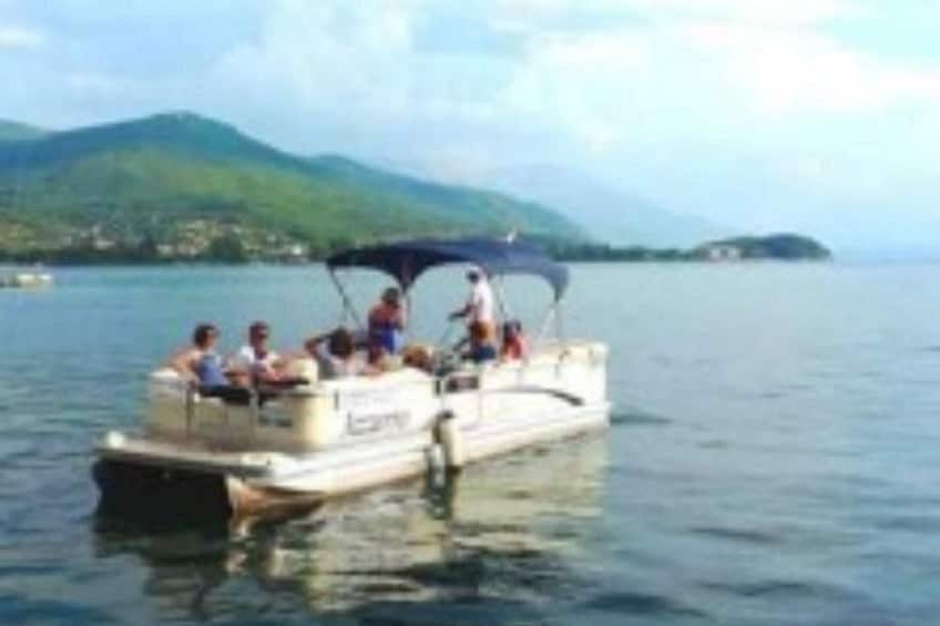 Un barco con gente, agua y una montaña distante. 2