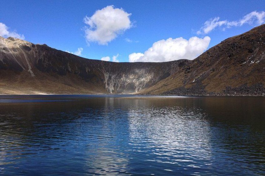 A calm lake surrounded by mountains under a clear sky. 3