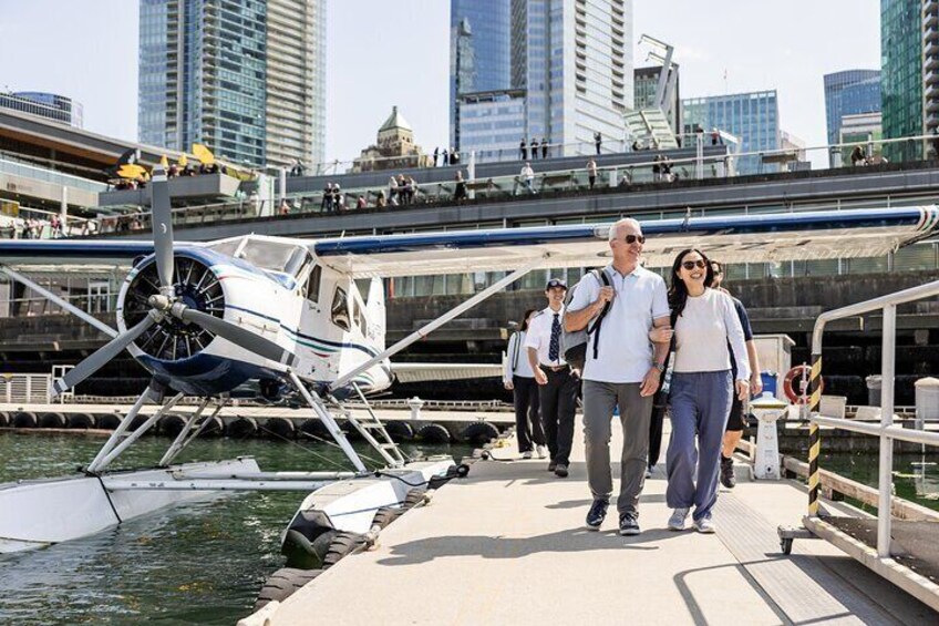 A man and woman walking on a bridge with a small aircraft on water. 5
