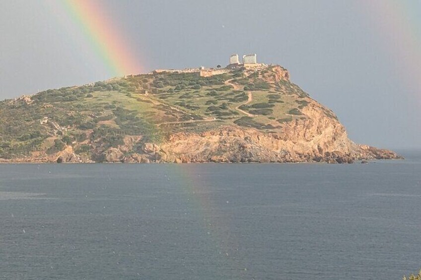 A coastal island with a castle, a rainbow, and a clear sky. 2