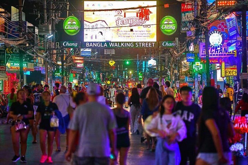 A crowded street with neon signs and advertisements. 1