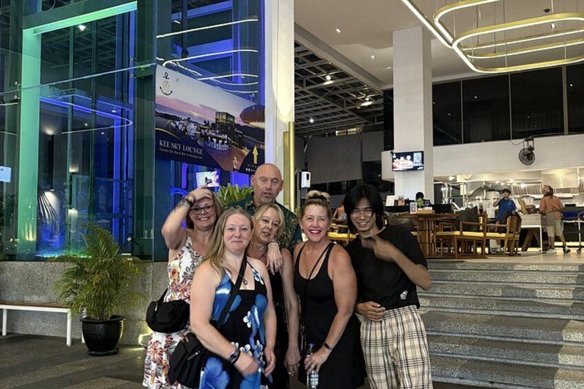 A group of people posing in front of a building with a sign that reads 'KEE'S LOUNGE.' 3