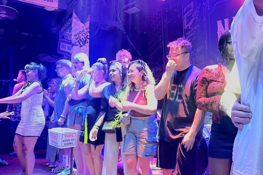A group of people on a stage with a sign that says 'TIPS KEEP US GOING.' 4