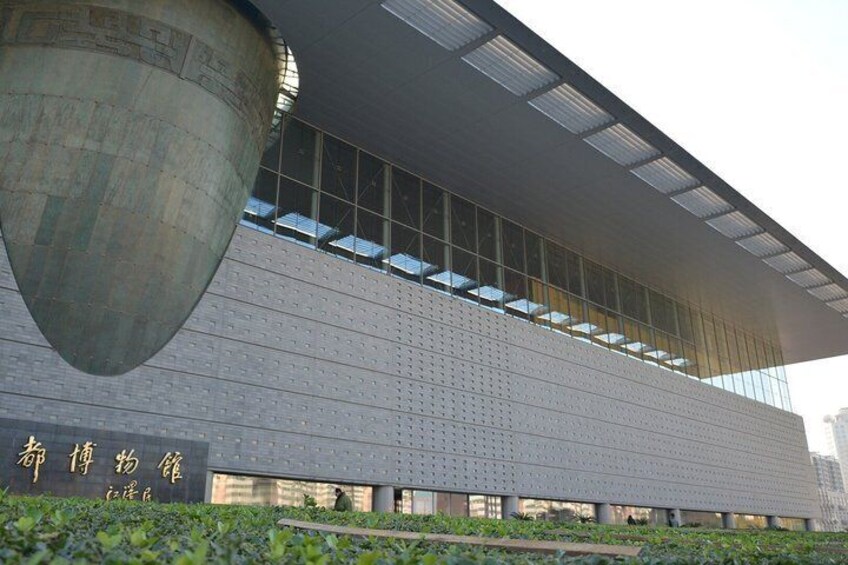 A modern building with a large, curved concrete structure and a grid of windows. 3
