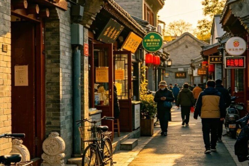 A narrow street lined with traditional buildings, a bicycle, and pedestrians. 1