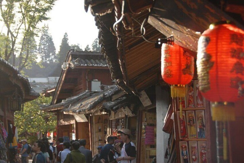 A traditional wooden building with a tiled roof, red lanterns, and a crowd of people. 4