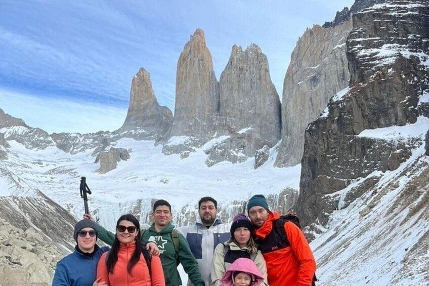 A group of people on a snowy mountain with rocky peaks in the background. 4