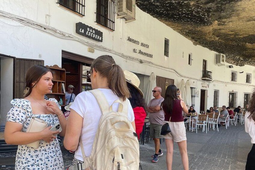 People standing outside a building with a sign that reads 'BAR LA ESCUEVA.' 4