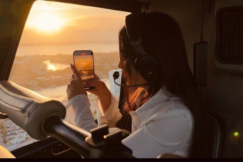 A person in a vehicle, wearing headphones, and holding a smartphone. 1