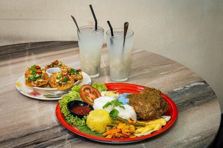 A meal with a red plate, a glass of iced drink, and a plate of fried snacks. 5