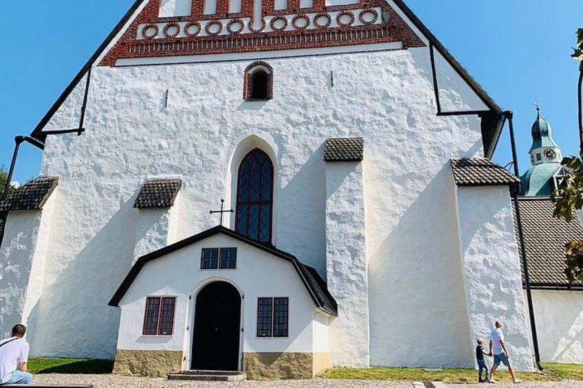 A white church with a black door, a blue window, and a red roof. 5