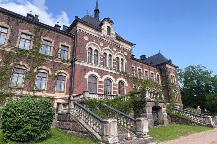 A historic building with a grand staircase, arched windows, and a prominent tower. 1