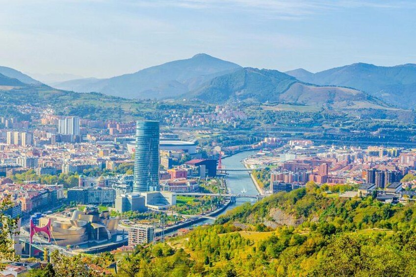 Un paisaje urbano con un moderno rascacielos destacado, un río y colinas circundantes. 5