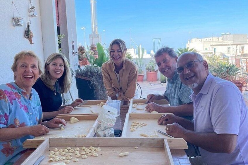 Un grupo de personas en una mesa con masa y un rodillo, probablemente preparando comida. 1