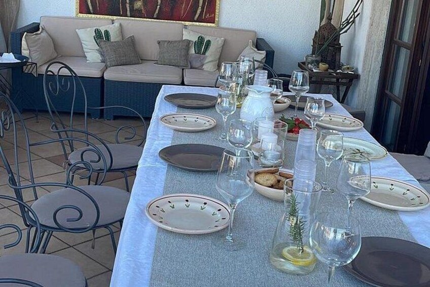 Un espacio de comedor al aire libre con una mesa preparada para una comida, rodeada de sillas y un sofá. 2