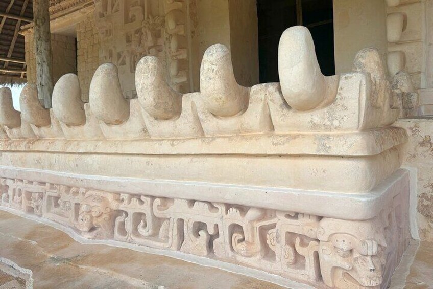 A stone structure with carved figures and a decorative border. 2