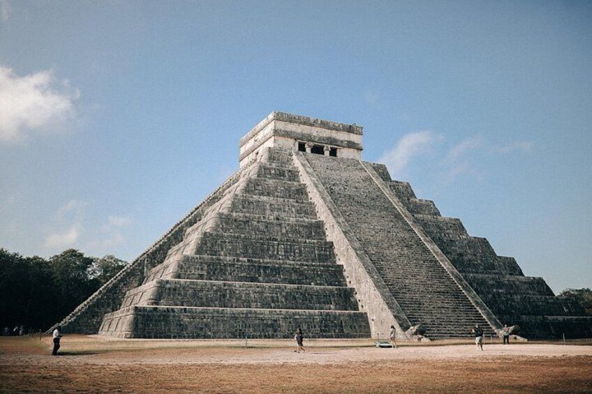 A large pyramid with a staircase leading to the top, surrounded by a flat area. 1