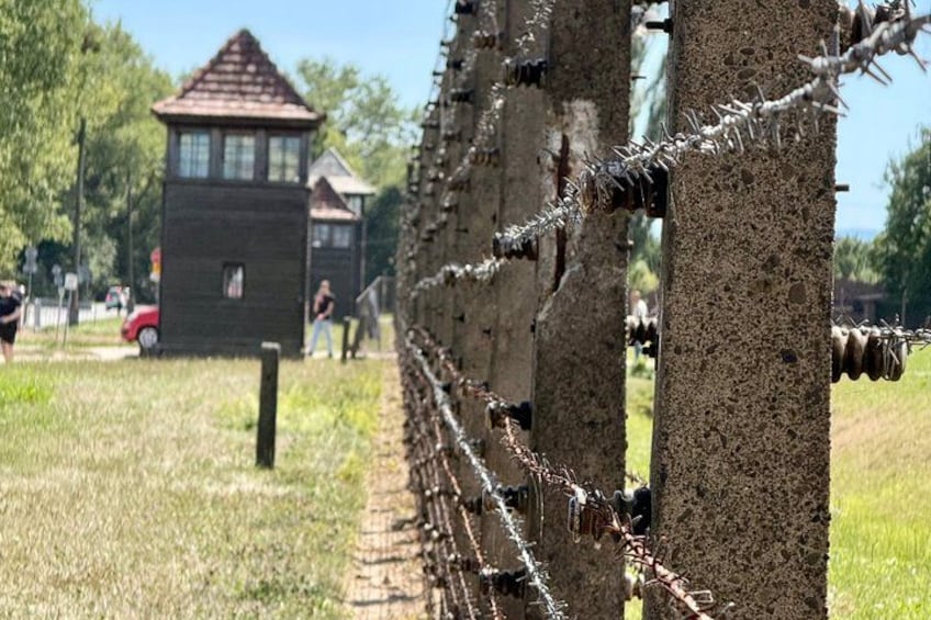 A barbed wire fence, a wooden structure, and a grassy area. 3