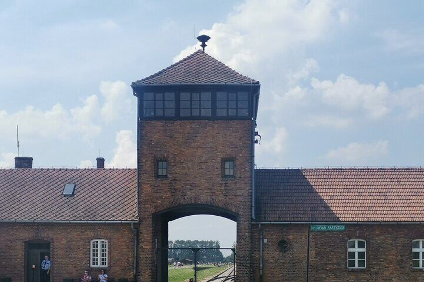 A brick building with a tower and arched entrance. 1