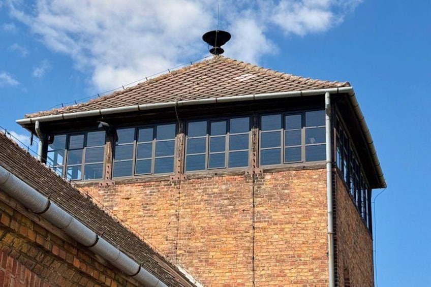 A brick building with a tiled roof and large windows. 4
