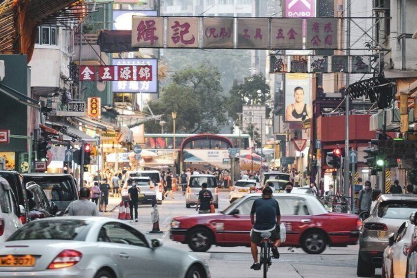 A busy urban street with cars, bicycles, and pedestrians. 2