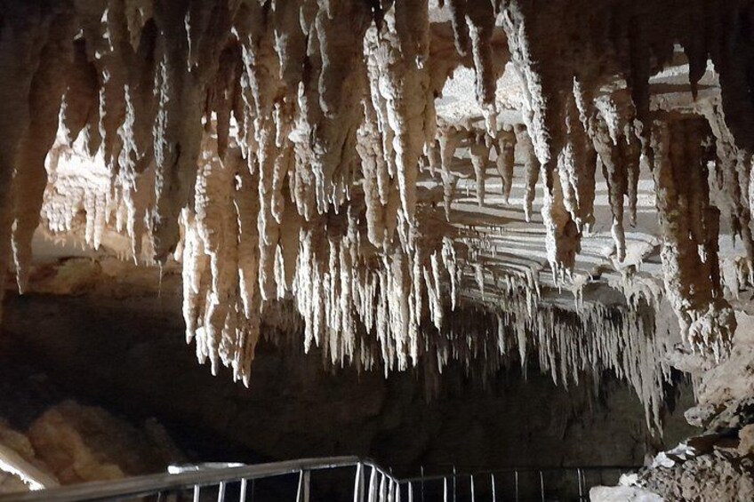 A cave with stalactites hanging from the ceiling. 5
