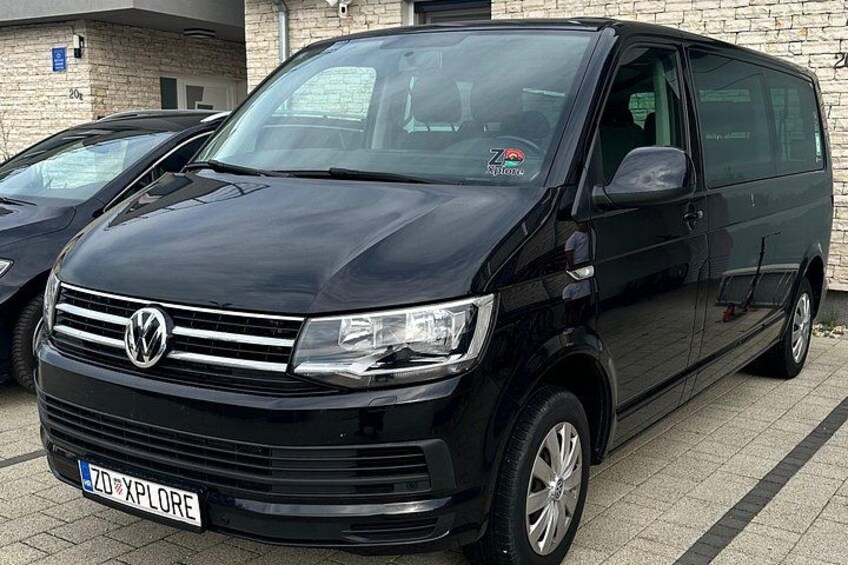 A black Volkswagen van parked in a lot. 2